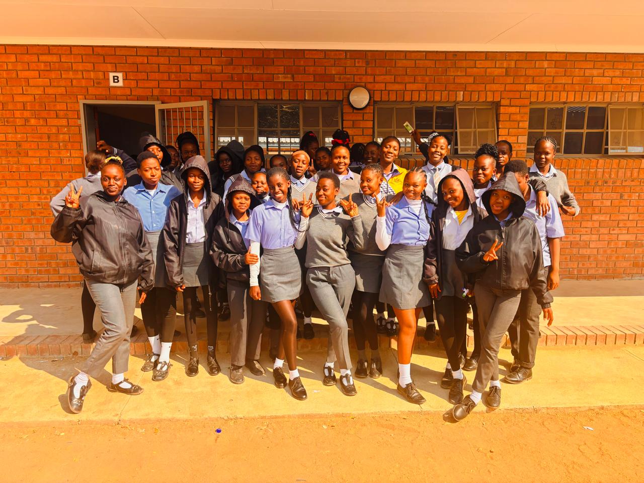 group of students in school uniforms smiling